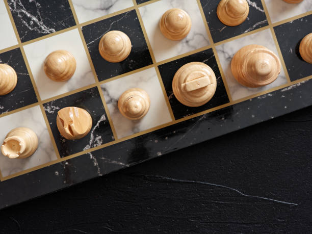 istock Top view of chessboard with pieces on black background. 1387221945