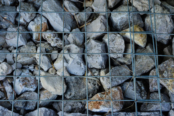 istock Wall of stones held by a metal mesh. Wide panoramic texture for background and design. 1387222532