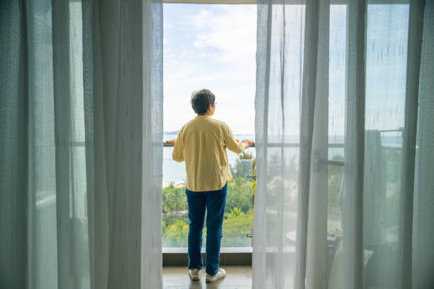 istock Senior women standing on the balcony looking out 1387223684
