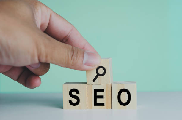 istock wooden cubes for SEO Search engine optimization magnifying glass icon on background.Copy space. 1387224330