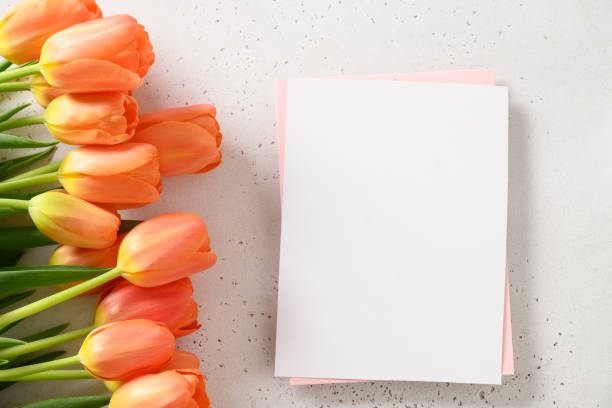 istock Fresh orange tulips and empty blank for letter. 1387224488