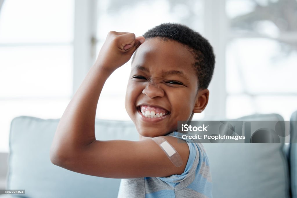Portrait of a little boy with a plaster on his arm after an injection I'm a brave boy! Vaccination Stock Photo