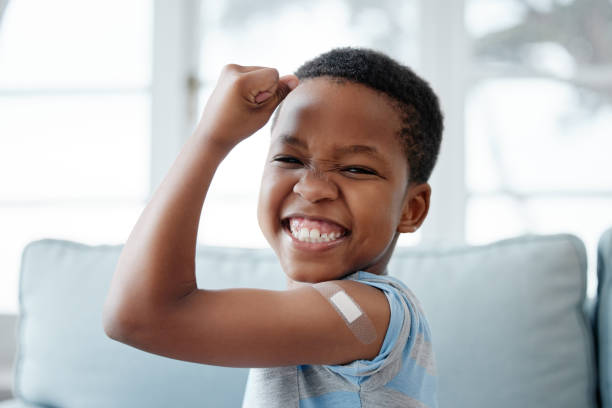Portrait of a little boy with a plaster on his arm after an injection stock photo