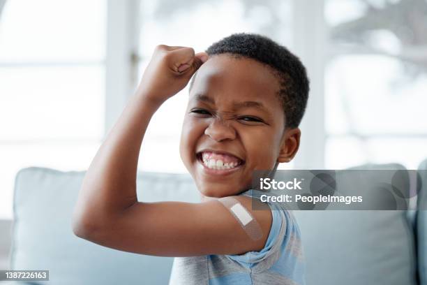 Portrait Of A Little Boy With A Plaster On His Arm After An Injection Stock Photo - Download Image Now