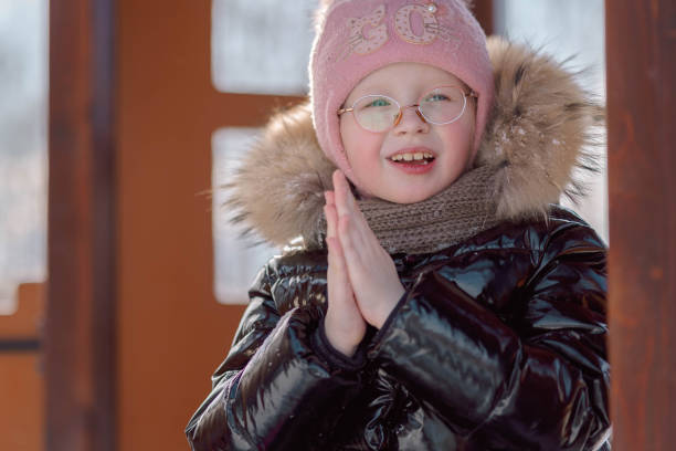 menina aquece seus tornozelos congelados em uma caminhada em um dia de inverno gelado - playground snow winter little girls - fotografias e filmes do acervo