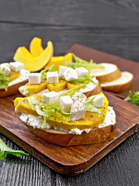 istock Bruschetta with pumpkin and arugula on black board 1387227274