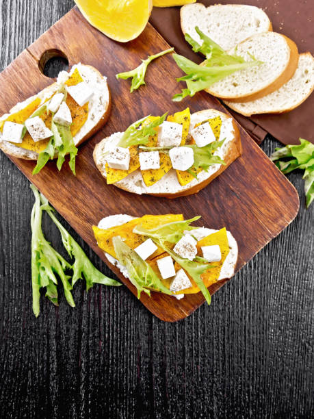 istock Bruschetta with pumpkin and arugula on dark board top 1387227276