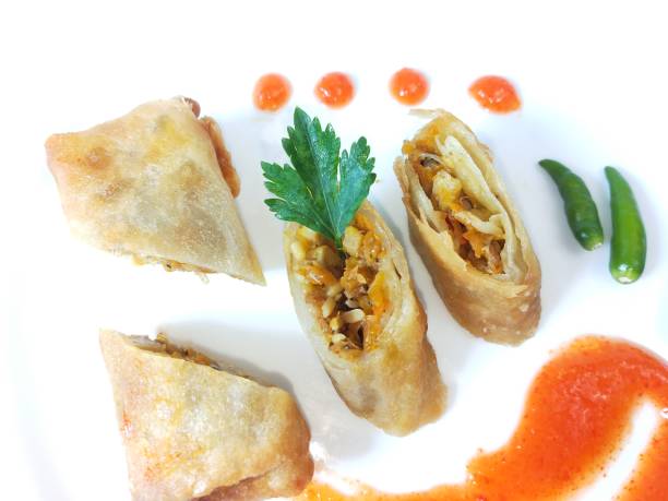 Lumpia Lumpia is a typical Central Javanese Indonesian snack consisting of a mixture of young bamboo shoots, eggs, fresh vegetables, and meat or seafood, in a roll made of thin sheets of wheat flour gorengan stock pictures, royalty-free photos & images