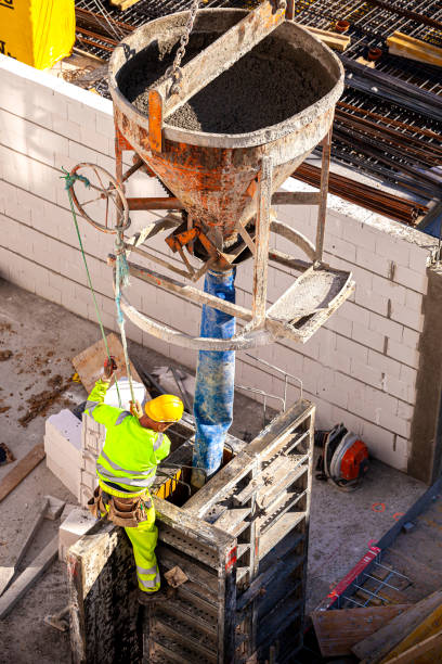Concrete pouring bucket for crane Concrete pouring on the construction site. Formwork for Concrete Structures. Concrete pouring bucket for crane. Concrete bucket transporting by crane to formwork. concrete in formwork stock pictures, royalty-free photos & images