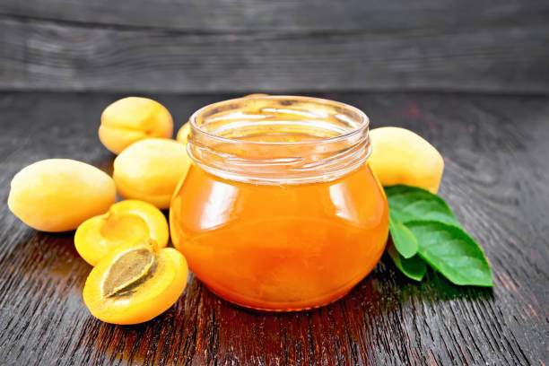 istock Jam apricot in jar on dark board 1387229342