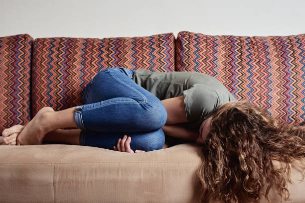 Woman Lying On Sofa, Suffering From Abdominal Pain Photo taken in Gomel', Belarus chronic illness stock pictures, royalty-free photos & images