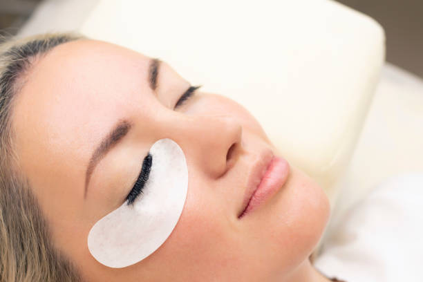 istock Eyelash extension procedure. Woman eye with long eyelashes. 1387237587
