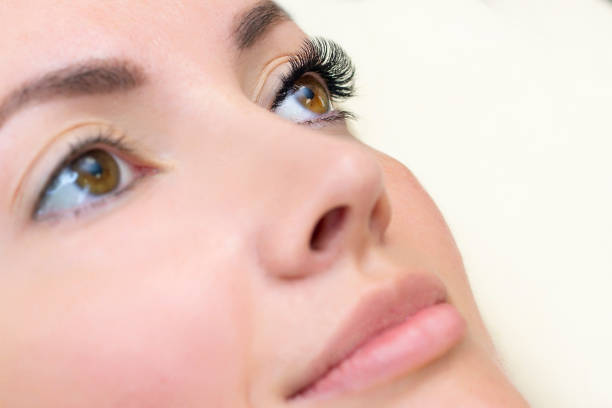 istock Eyelash extension procedure. Woman eye with long eyelashes. 1387237634