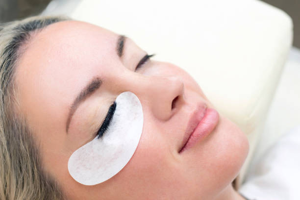 istock Eyelash extension procedure. Woman eye with long eyelashes. 1387238055
