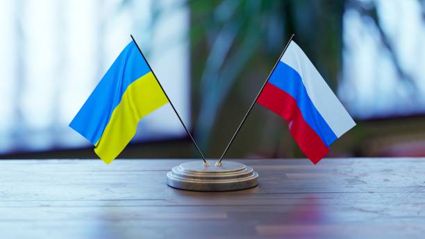 Russian and Ukrainian flags on a desk Russian and Ukrainian flags on a desk over defocused background russian flag stock pictures, royalty-free photos & images