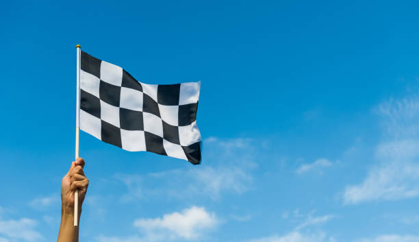 istock Hand holding checkered race flag in the air 1387242520