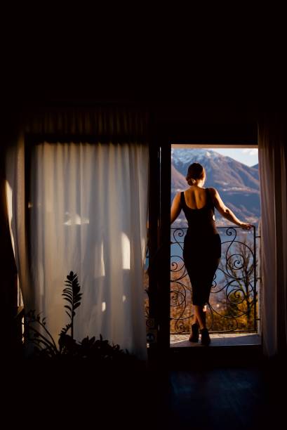 istock Young woman relaxes on balcony, over lake 1387244035