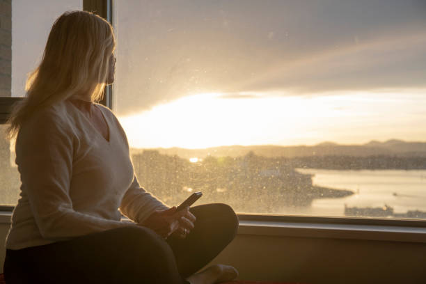 la donna si rilassa sulla sporgenza della finestra, all'alba - looking through window individuality old architecture foto e immagini stock