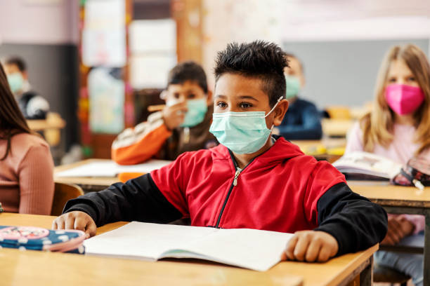istock A smart Indian boy sits in classroom during corona virus and following lecture. 1387245031