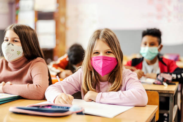 istock An elementary school student writing on a class with schoolmates during covid 19. 1387245539