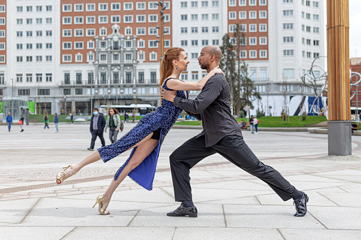Madrid, Spain. March 9 2022. Multiracial couple dancing tango in Plaza de España in Madrid, Spain