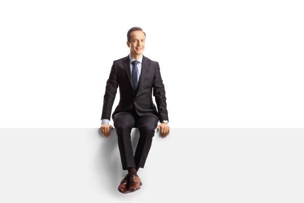 istock Professional man in suit and tie sitting on a blank panel 1387248332