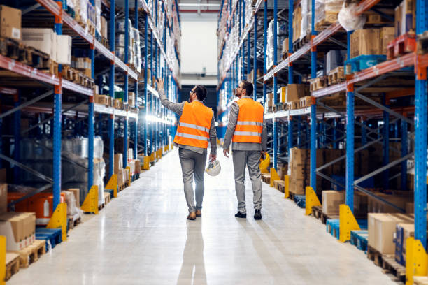 Businessman showing storage to his business partner. Two businessmen walking around storage. warehouse stock pictures, royalty-free photos & images