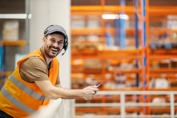 istock Happy delivery center manager with tablet smiling at the camera. 1387248825