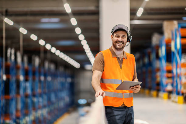 retrato de um gerente expresso de postagem com fone de ouvido de escolha de voz segurando tablet e sorrindo para a câmera. - freight transportation audio - fotografias e filmes do acervo