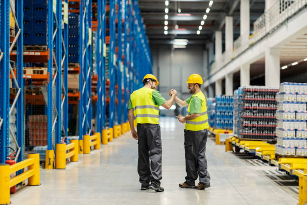 two warehouse workers having bro handshake for teamwork. - manual worker handshake industry warehouse imagens e fotografias de stock