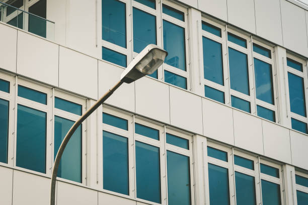 a modern office building with a street lamp in the foreground in the city
