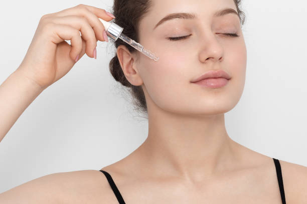 istock Young woman applying serum to her face. 1387256485