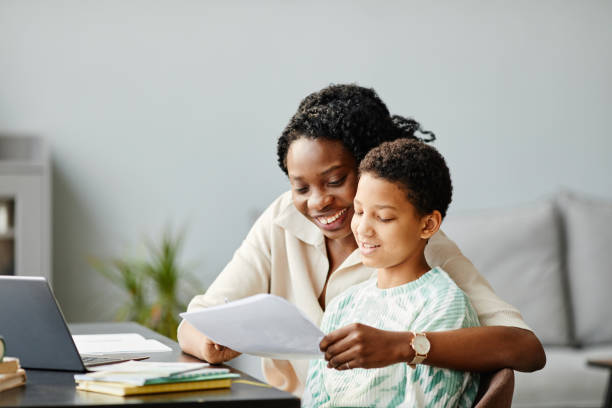 istock Happy Mother Helping Daughter with Homework 1387257096