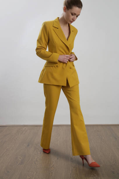 istock Female model wearing yellow tailored suit. Studio shot. 1387258105
