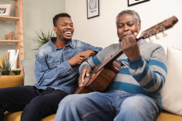 istock Senior African American playing a guitar for his son 1387259287