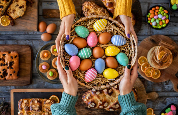 ręka dwóch kobiet z wielkanocnymi bułeczkami i pisankami. paskalya çöreği . - bread food basket sweet bun zdjęcia i obrazy z banku zdjęć