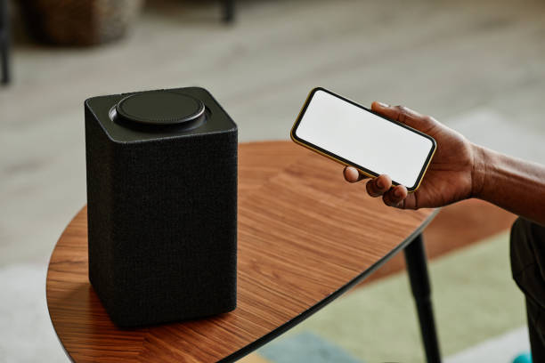 istock Connecting Phone to Smart Speaker Close Up 1387261930