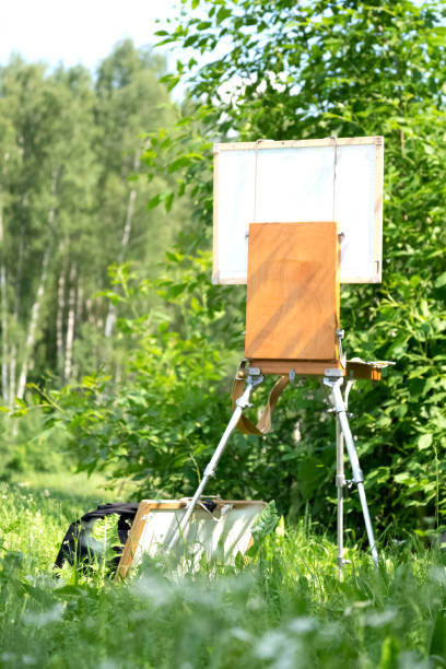 istock Artist's easel stands among the summer greenery 1387263493