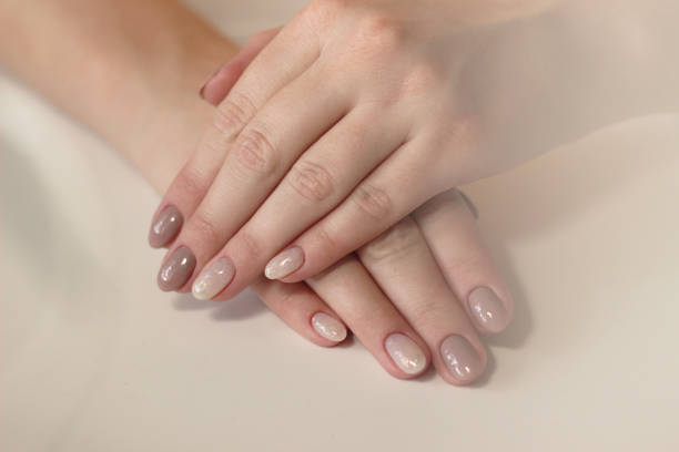istock close-up tenderness neutral beige manicure with glitter two hands 1387264177
