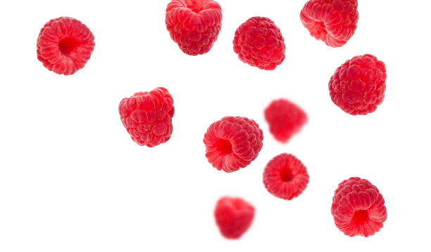 istock Flying raspberries isolated on white background. Sweet ripe fresh delicious raspberry, summer berry, organic food, vitamins. Creative background with falling raspberry fruits 1387266711
