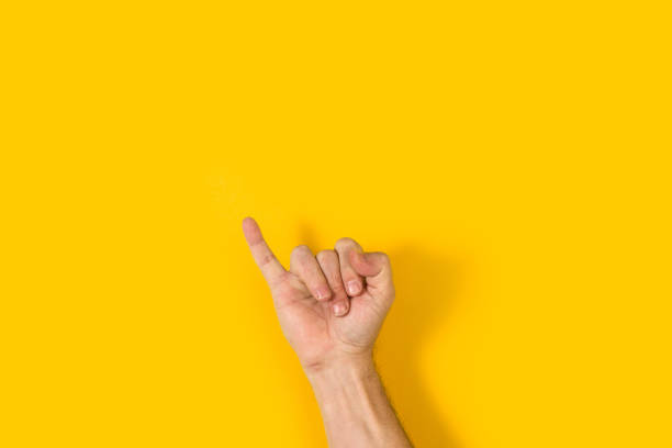 Man hand with little finger raise on a yellow background Man hand with little finger raise on a yellow background with copy space pinky finger stock pictures, royalty-free photos & images