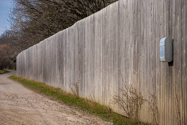 Unpainted wooden fence with a postbox on a sunny day of spring in Valbyparken which is a public park in Valby, an old suburb to the Danish capital Copenhagen