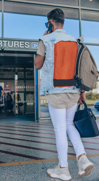 istock Man with baggage going at airport 1387269856