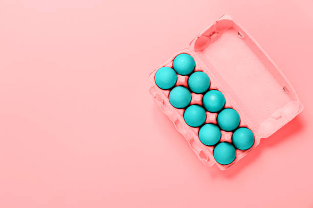 istock Package of chicken Easter eggs painted in blue color on pink background. Copy space. Banner. Religion holiday concept. Mockup design. Neon minimalist style. Soft tint 1387270357