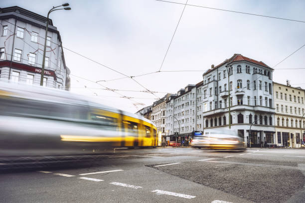 long exposure of yellow street car and cars passing crossroad in Berlin Mitte at early morning at Rosenthaler Platz