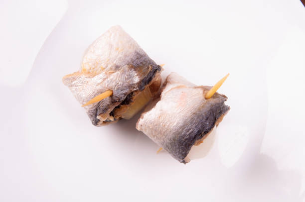 istock Beer Fest - rollmops - typical german delicacy with raw sardines wrapped in pickled onionswhite background 1387272959