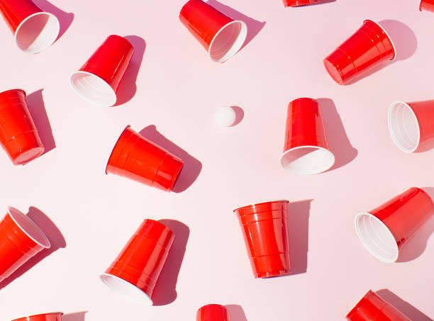 istock Red plastic beer pong cups on pink background. Flat lay. 1387273796