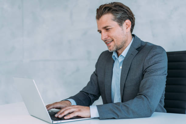 istock Successful businessman in modern office working on laptop. 1387274040
