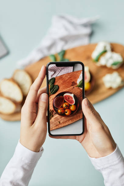 Mobile Food Photography Minimal Minimal top view of young woman taking aesthetic photo of food using smartphone in home studio brand name smart phone photos stock pictures, royalty-free photos & images