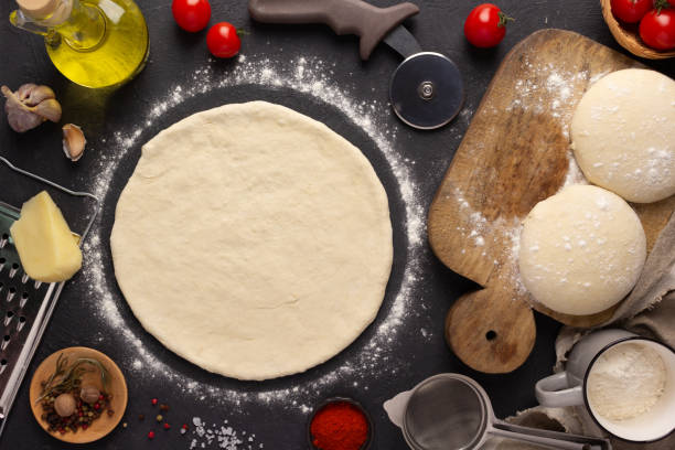istock Pizza homemade cooking or baking at table. Dough pizza on slate tabletop background 1387275310